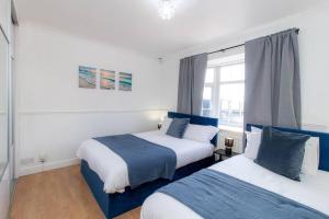 2 Betten in einem weiß-blauen Zimmer in der Unterkunft K Suites - Rowley Road in Dudley