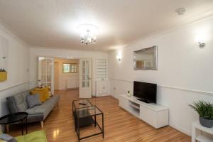 ein Wohnzimmer mit einem Sofa und einem TV in der Unterkunft K Suites - Rowley Road in Dudley
