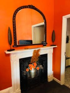 a fireplace with a mirror on top of it at horn and trumpet in Bewdley