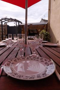 une table en bois avec une assiette et des verres dans l'établissement La Osmonière - Maison 6 personnes - Tout inclus, à Saint-Méloir-des-Ondes