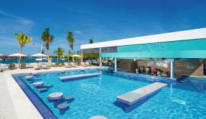 uma piscina num resort com cadeiras e guarda-sóis em Riu Montego Bay - Adults Only - All Inclusive em Montego Bay