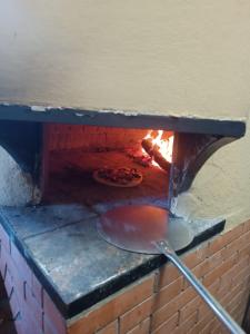 um forno de tijolos com uma pizza em Oasi ristoro dell' Etna em Piedimonte Etneo