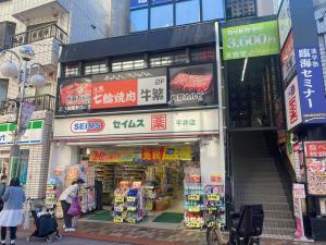 una tienda en una ciudad con gente caminando delante de ella en tokyo Large family vacation rentals en Tokio