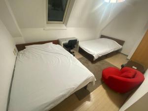 a small room with a bed and a red chair at tokyo Large family vacation rentals in Tokyo