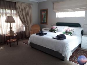 a bedroom with a large white bed with towels on it at By The Beach - Beachfront Apartment & Home in Langebaan