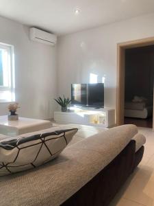 a living room with a couch and a flat screen tv at Central City Nest - Sandra&David in Zadar