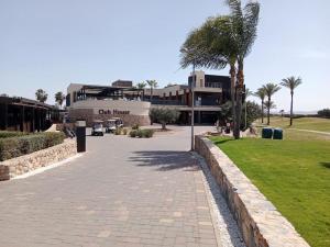 a walkway in front of a building with a palm tree at El Oasis de Roda Golf Apartment in San Javier