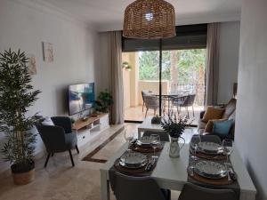 a living room with a table and a tv at El Oasis de Roda Golf Apartment in San Javier