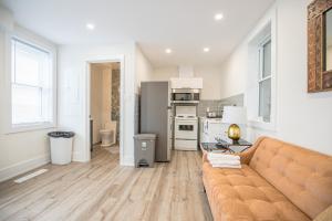 a living room with a couch and a kitchen at Cozy Private Apartment - 3 minutes from Downtown with free parking in Ottawa