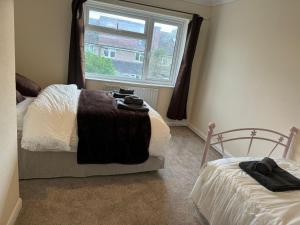 a bedroom with two beds and a window at Entire three bedrooms house in London