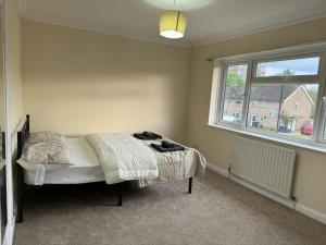 a bedroom with a bed and a window at Entire three bedrooms house in London