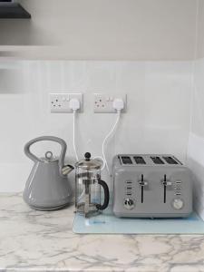 a kitchen counter with a toaster and a tea kettle at Serenity Ballycastle in Ballycastle