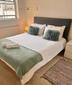 een slaapkamer met een bed met kussens en een raam bij Hyde Park,3 min walk,Family home! 2 Bedrooms & 2 Bathrooms Apartment! Fantastic Location in Londen
