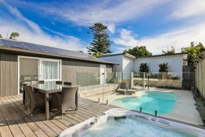a backyard with a swimming pool and a patio with a table and chairs at Perfect Beach getaway in Narrabeen