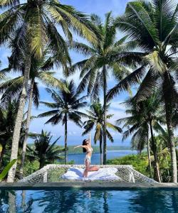 una donna in una piscina con palme di SPICE TRADER a Nusa Penida