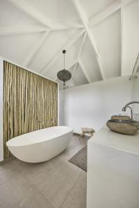 Baño blanco con bañera y lavamanos en Patrick Street Villa, en Avalon