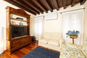 a living room with a couch and a television at Venice Heaven Apartments San Marco, a stone's throw away from San Marco Square in Venice