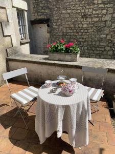 einen Tisch mit einem Tee-Set auf einer Terrasse mit 2 Stühlen in der Unterkunft The Cool Lounge à Coulonges - Charente in Coulonges