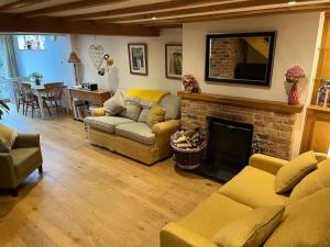 sala de estar con sofá y chimenea en South Downs Cottage With Views, en Poynings