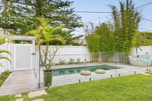 une cour avec une piscine et une clôture dans l'établissement Freshwater Beach House, à Freshwater