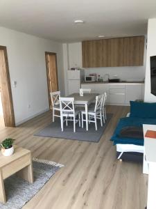 a living room with a table and chairs and a kitchen at Apartman SLAVONIA 2 in Đakovo