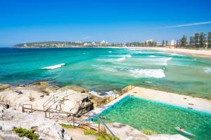 a swimming pool on a beach next to the ocean at Beachfront Magic Unbeatable Location in Sydney