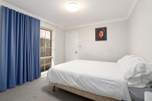 1 dormitorio con cama blanca y ventana en Hidden Hideaway - Family Friendly, en Sídney