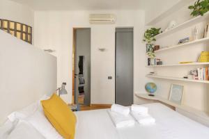 um quarto com uma cama branca e uma almofada amarela em • Grazioso appartamento tra City Life e San Siro •  em Milão