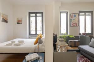 a bedroom with a bed and a living room with a couch at • Grazioso appartamento tra City Life e San Siro •  in Milan