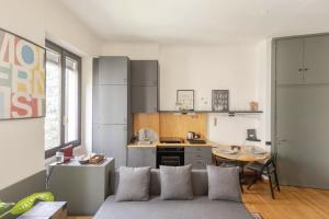 a living room with a couch and a kitchen at • Grazioso appartamento tra City Life e San Siro •  in Milan