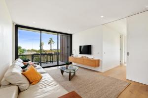 a living room with a couch and a glass table at Modern Home on Freshwater Beach in Freshwater