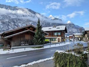 a house on the side of a road with mountains at Alpine chalet apt w/parking and porch in Meiringen