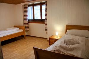 a room with two beds and a window in it at Alpine chalet apt w/parking and porch in Meiringen