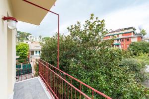 balcón con barandilla roja y árbol en ALTIDO Blissful Flat for 6, Close To The Beach, en Santa Margherita Ligure