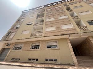 un grand bâtiment avec des fenêtres et des escaliers. dans l'établissement Annour Luxurious & Large apartment in Oujda Centre, à Oujda
