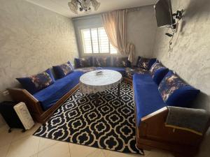 - un salon avec un canapé bleu et une table dans l'établissement Annour Luxurious & Large apartment in Oujda Centre, à Oujda
