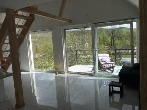 a living room with two windows and a balcony at Apartman TERASA in Beljevina