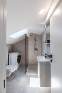 a white bathroom with a toilet and a sink at Villa Carpe Diem in Zečevo