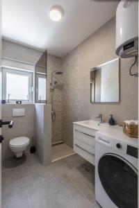 a bathroom with a toilet and a sink and a shower at Villa Carpe Diem in Zečevo