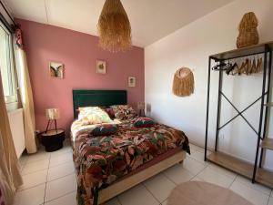 Schlafzimmer mit einem Bett und rosa Wänden in der Unterkunft Maison vue mer, port et ville in Fécamp