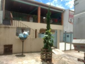 a plant in front of a building with a fence at Suite para seu descanço in Indaiatuba