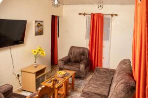 un soggiorno con divano, sedie e TV di Hilda's place a Embu