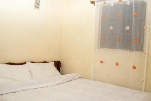 a bedroom with a bed and a window with orange butterflies at Hilda's place in Embu