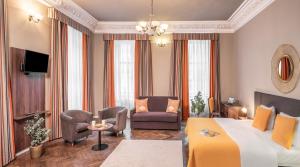 een hotelkamer met een bed en stoelen en een televisie bij Hotel "Palác U Kočků" by Adrez, Palace At the Cats in Praag
