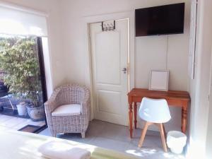 Habitación con escritorio, silla y TV. en Dressage B&B, en Ciudad del Cabo