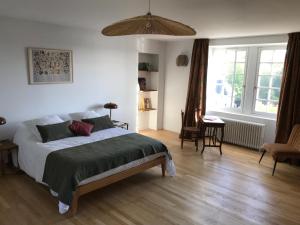um quarto com uma cama, uma mesa e cadeiras em La Grimaudière em La Chapelle-sur-Erdre