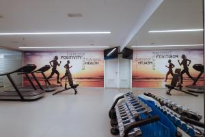 a gym with fitness equipment and posters on the walls at Don Gregory by Dunas - Adults Only in San Agustin