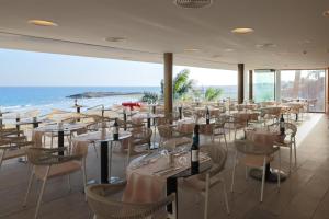 a restaurant with tables and chairs and the ocean at Don Gregory by Dunas - Adults Only in San Agustin