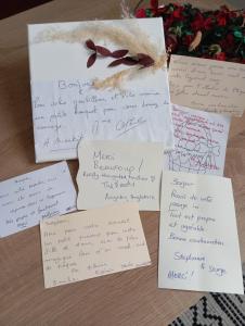 a pile of handwritten notes on a table with flowers at Appartement Cosy avec Terrasse in Vaux-sur-Seine
