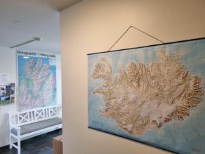 a large map hanging on a wall next to a crib at The Northern Comfort Inn in Ólafsfjörður